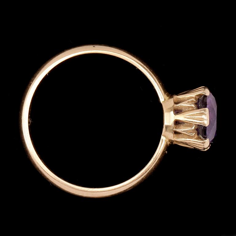 RING, 18k guld med rund fasettslipad violett sten. Vikt 5,7g.
