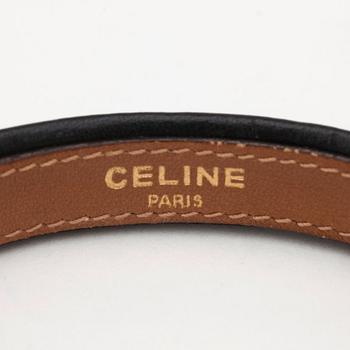 CÉLINE, a black leather bracelet.