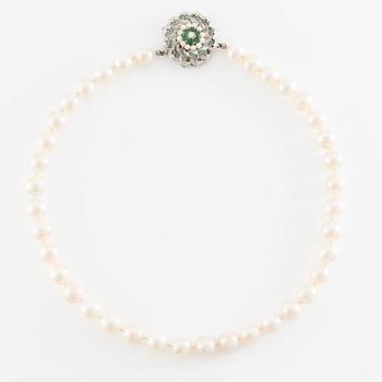 Pearl necklace, cultured pearls with a clasp in 18K white gold set with emeralds, diamonds, and pearls.