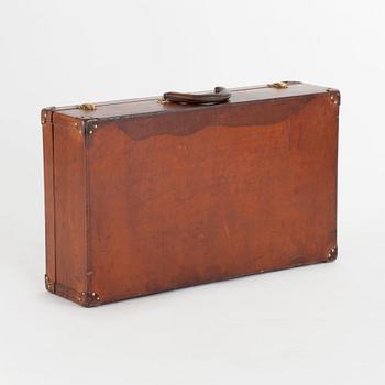 LOUIS VUITTON, a brown faux leather suitcase from around 1910.