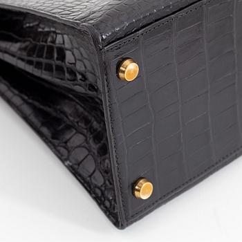 1962 black alligator 'Kelly' handbag by Hermès.