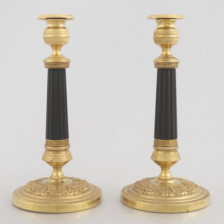 A pair of Empire gilt and patinated brass candlesticks, early 19th century.