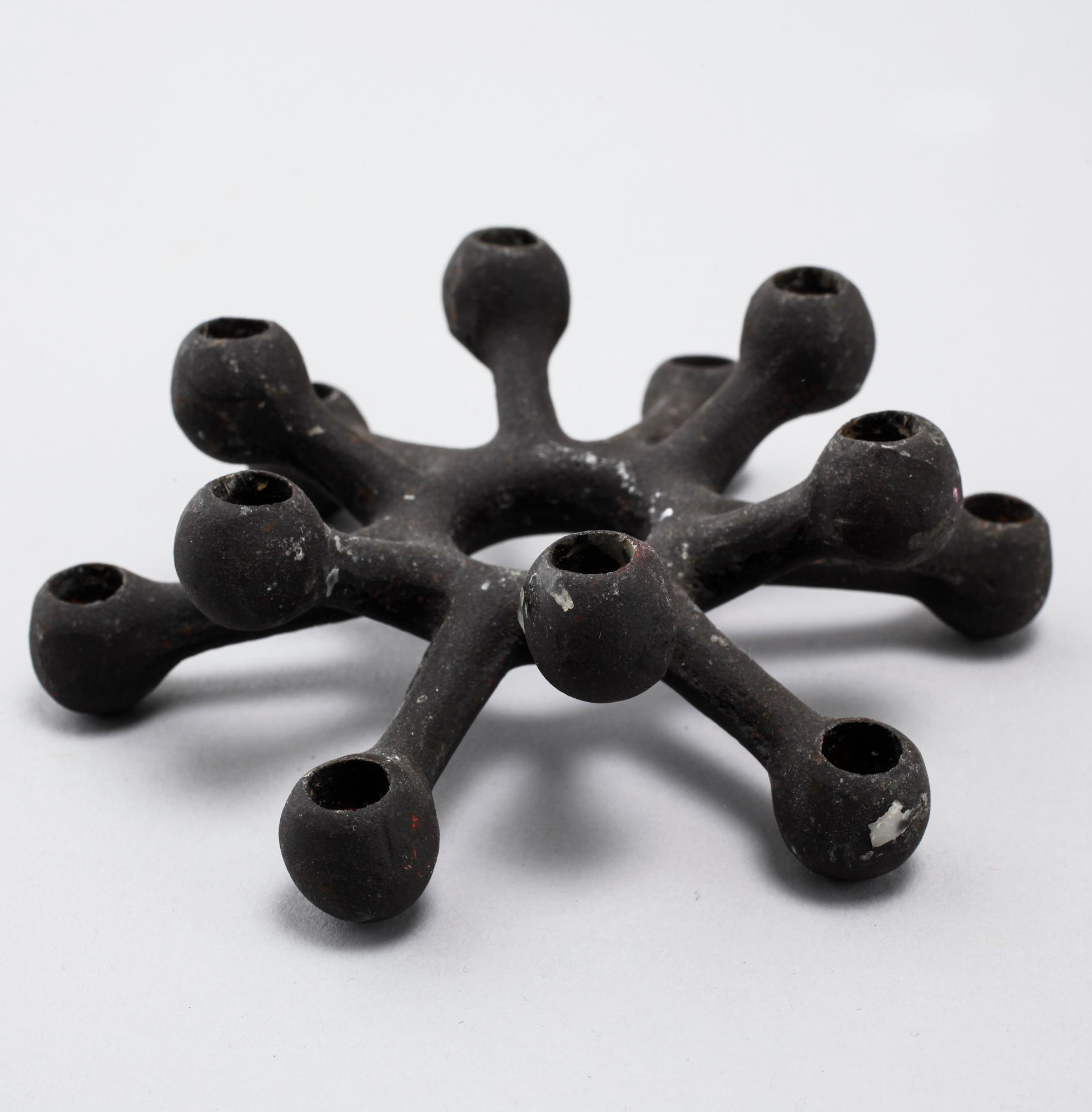 Four 1960s iron cast candle holders, designed by Jens Quistgaard for Dansk Designs .