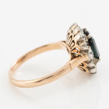 Ring in low carat gold with dark sapphire and white stones.