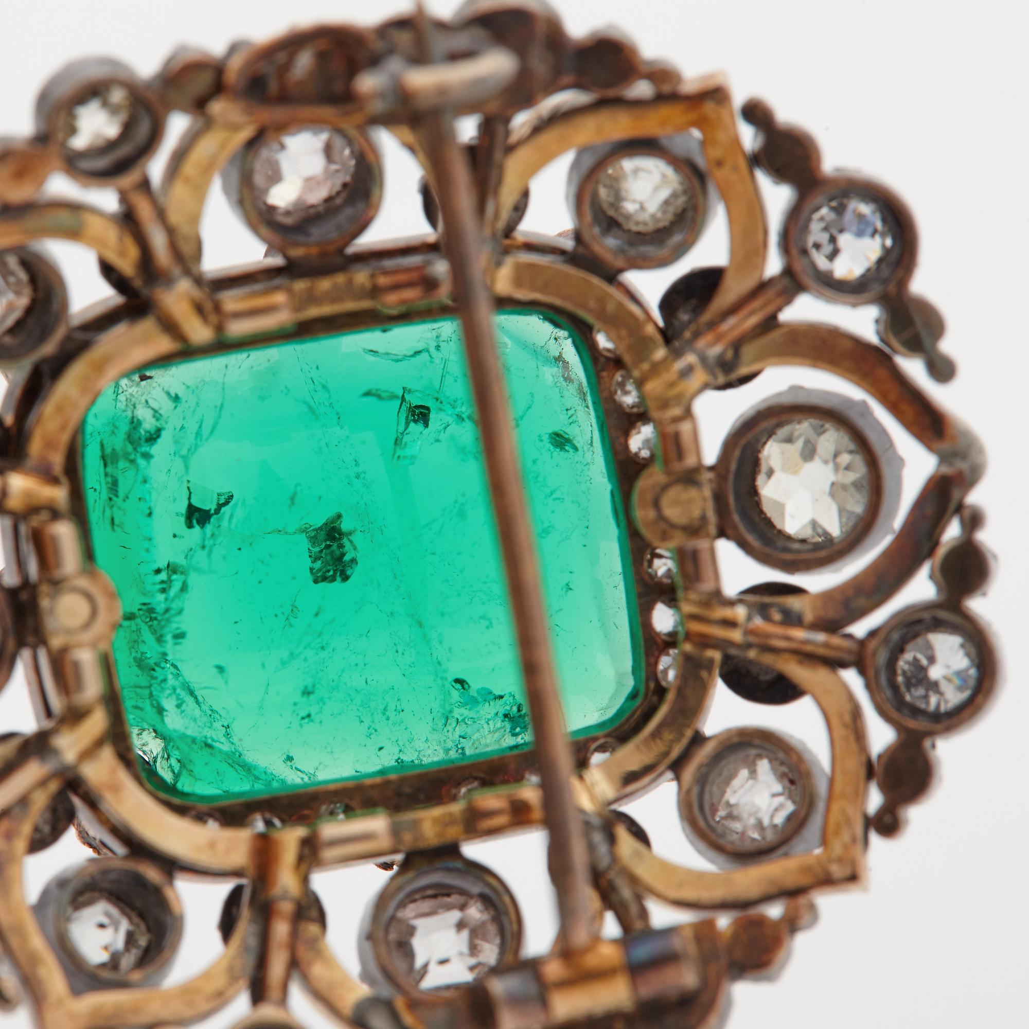 An emerald, black enamel and old cut diamond brooch. 19th century.