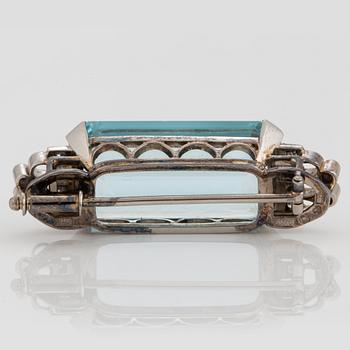 A CF Carlman brooch in 18K white gold set with a faceted aquamarine and eight-cut diamonds.