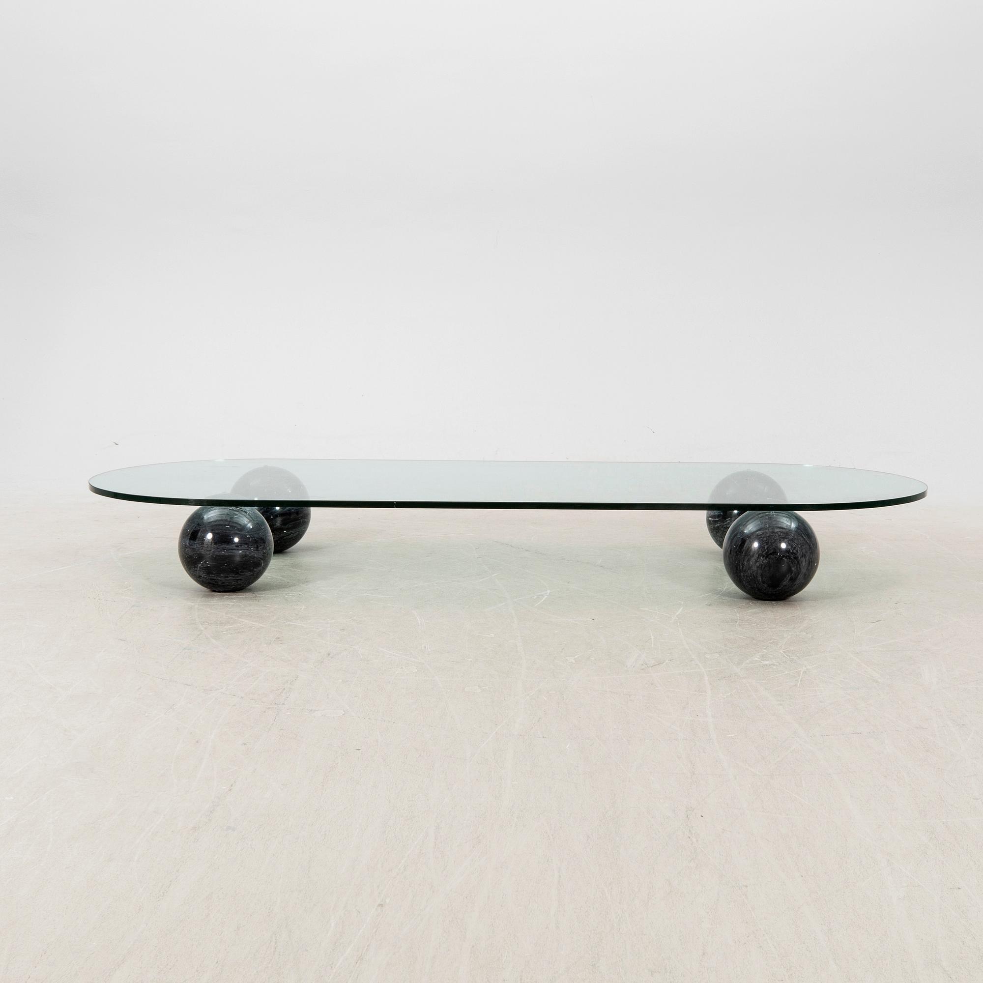 A glass and stone table from the late 20th century.