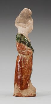 A green and yellow glazed figure of a standing lady, Tang dynasty.