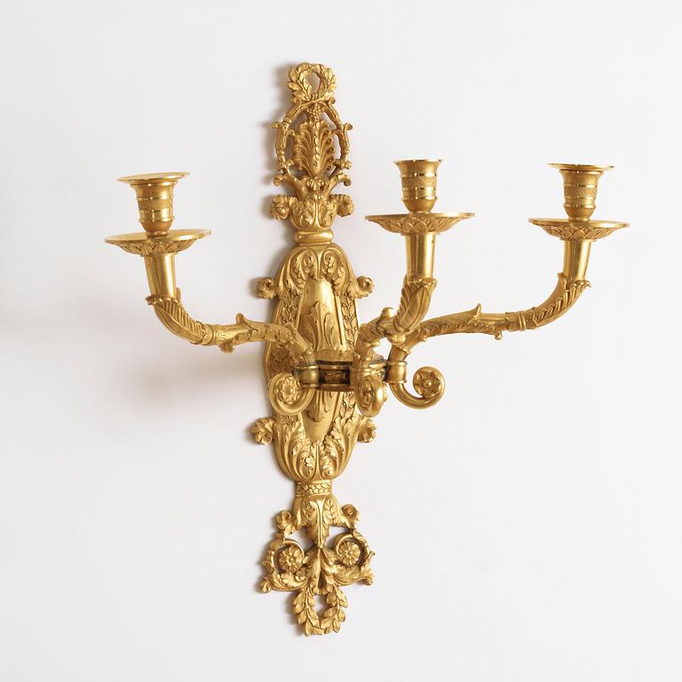 A pair of Empire-style late 19th century gilt bronze three-light wall-lights.