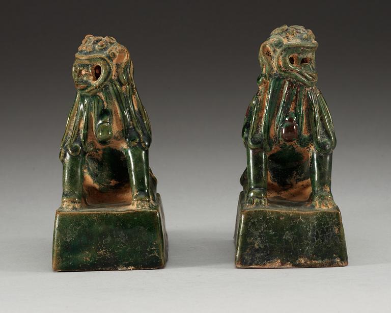 A pair of green glazed figures of 'Buddhist Lions', Ming dynasty.