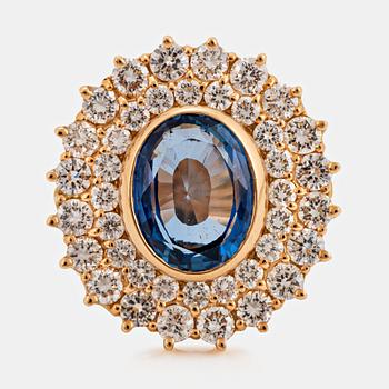 1013. An 18K gold ring set with a faceted sapphire ca 3.50 cts and round brilliant-cut diamonds.
