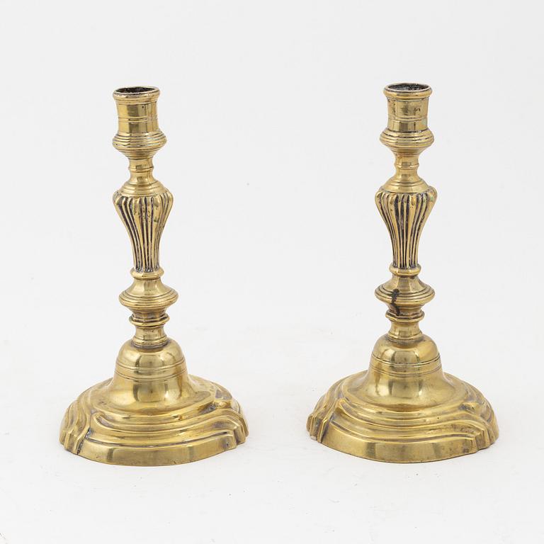 A pair of Rococo brass candlesticks, later part of the 18th Century.