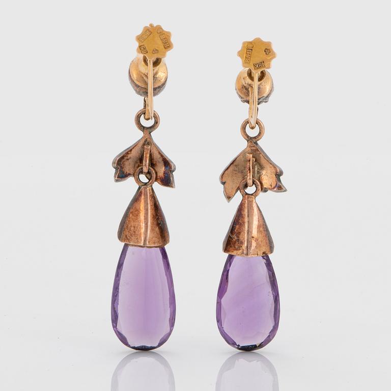 A pair of 14K gold and silver earrings set with faceted amethysts and rose-cut diamonds.