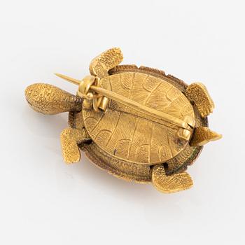 A brooch in the shape of a turtle.