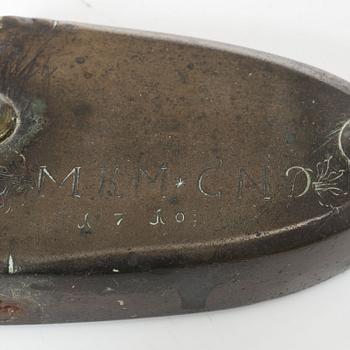 A brass clothes iron, dated 1710.