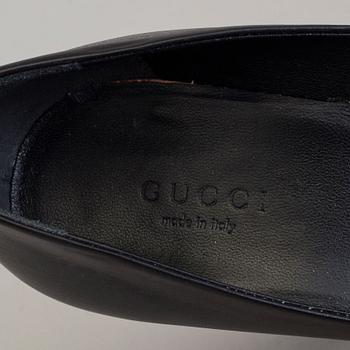 A pair of black pumps by Gucci.