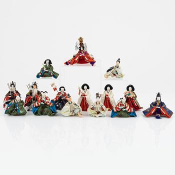 A Japanese wooden box with 15 small dolls, 20th Century.