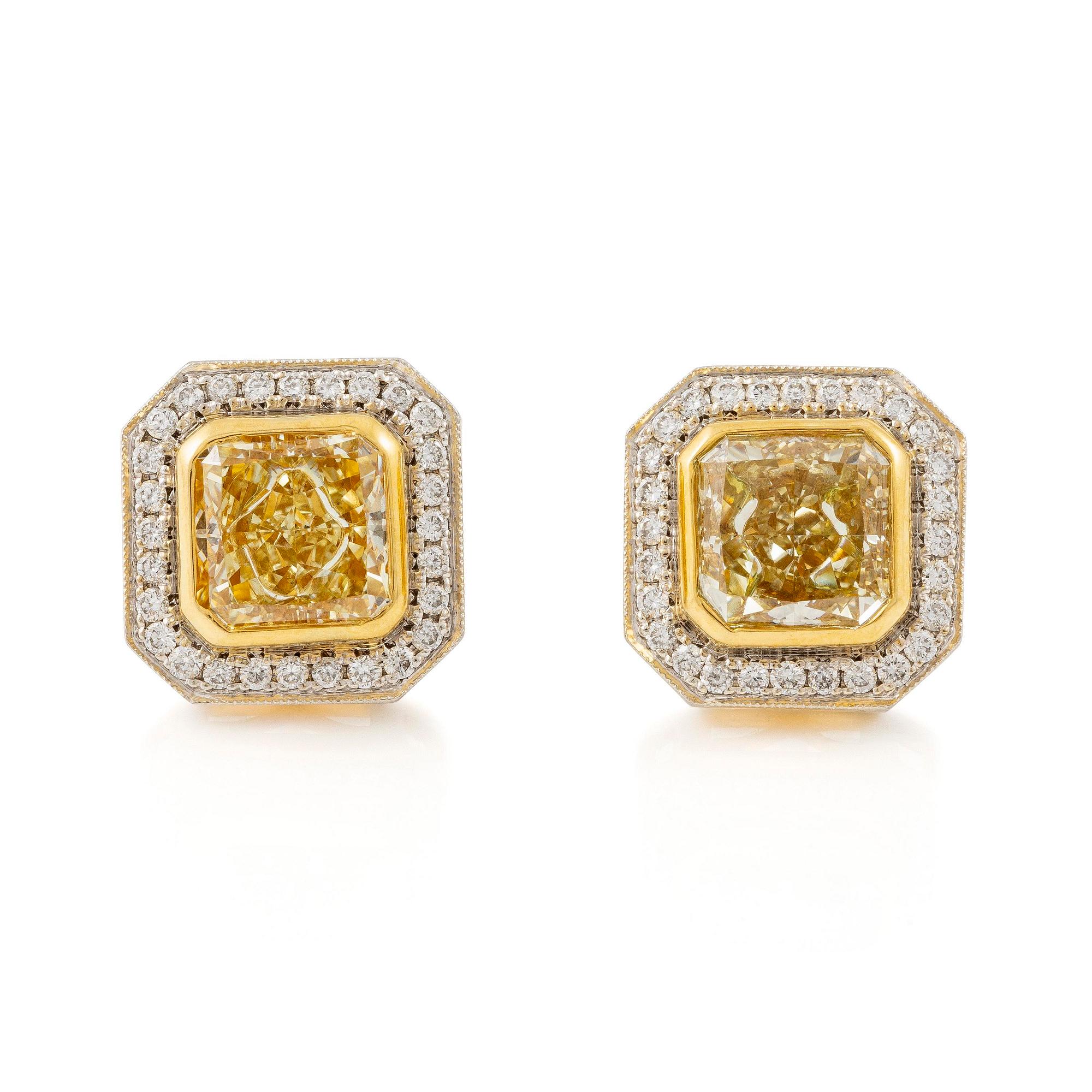 A pair of platinum and gold earrings with two radiant-cut yellow diamonds.