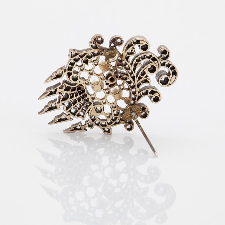 An 18K gold and silver brooch set with old- and rose-cut diamonds.