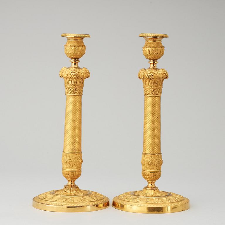 A pair of French Empire early 19th cenury gilt bronze candlesticks.