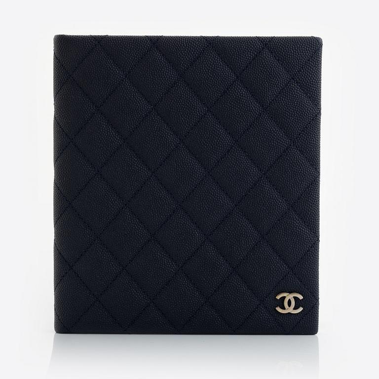 Chanel, a dark blue navy caviar leather notebook.