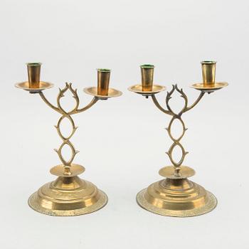 A pair of brass candelabras dated 1810 and 1812.