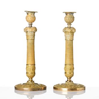 A pair of French Empire ormolu candlesticks, ca 1820's.