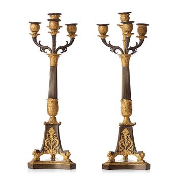 85. A pair of French Empire early 19th century gilt and patinated bronze four-light candelabra.