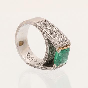 A 9K white gold ring with an emerald and brilliant cut diamonds.