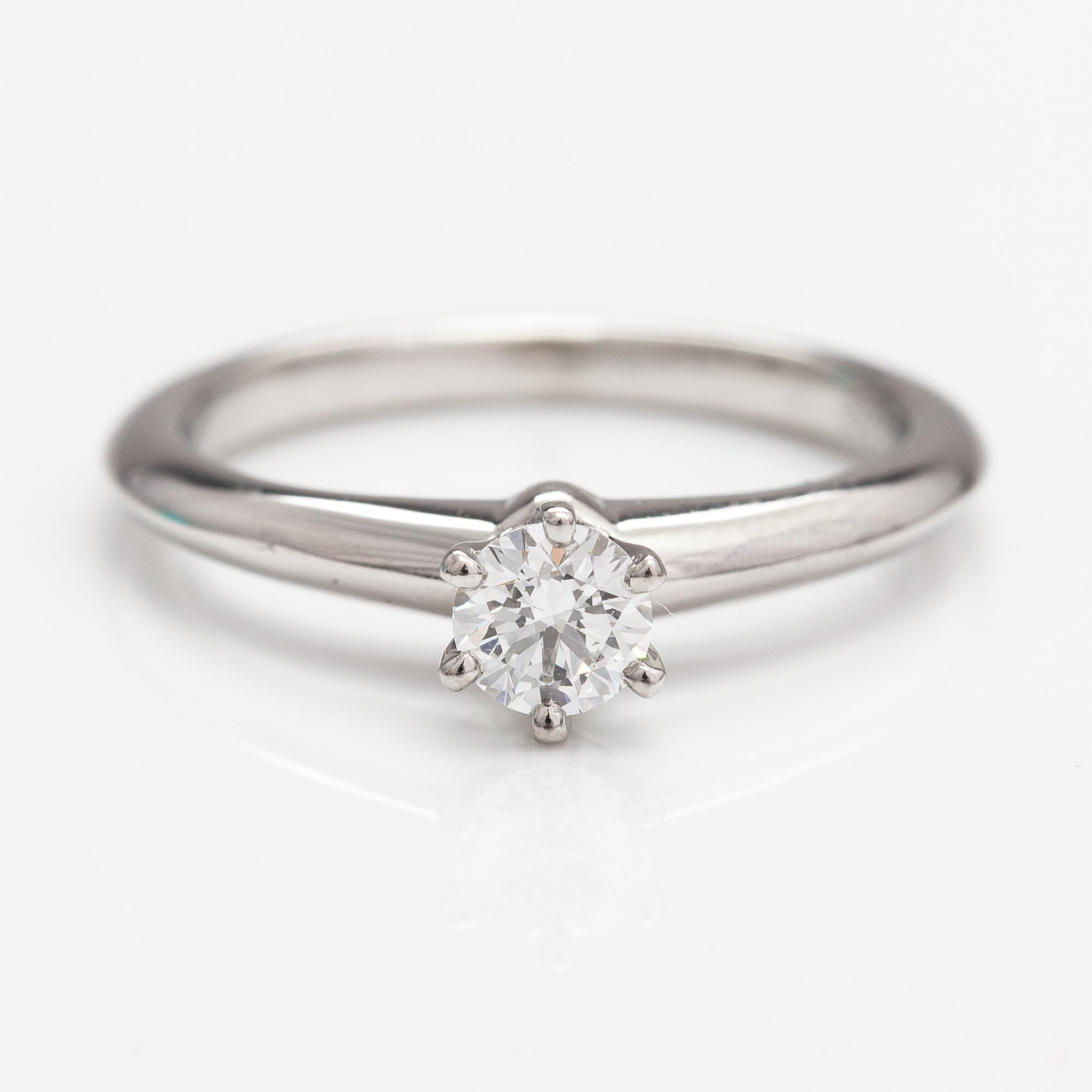 Tiffany & Co, A platinum ring with a ca. 0.26 ct diamond.