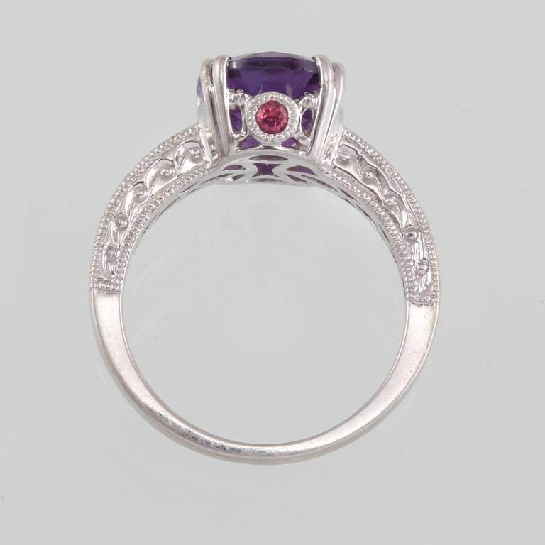 RING, 14K guld med ovalslipad ametist samt åtta briljantslipade diamanter. Vikt 4,6 gram.