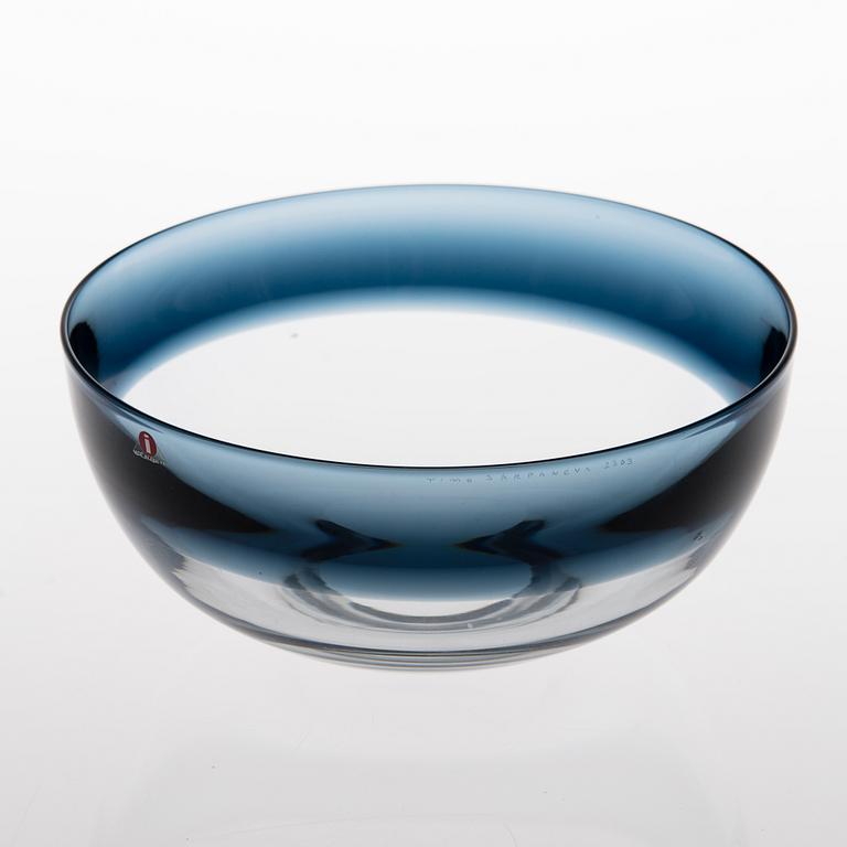 A clear glass bowl with a blue rim, signed Timo Sarpaneva 2303.