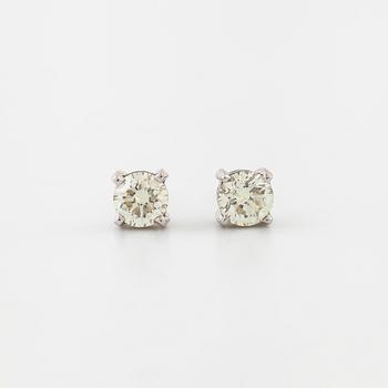 A pair of brilliant cut diamond earrings.