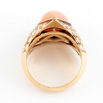 An 18K gold and coral ring set with round brilliant-cut diamonds.