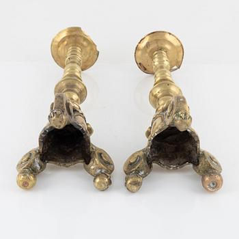 A pair of brass candle sticks, around 1700.