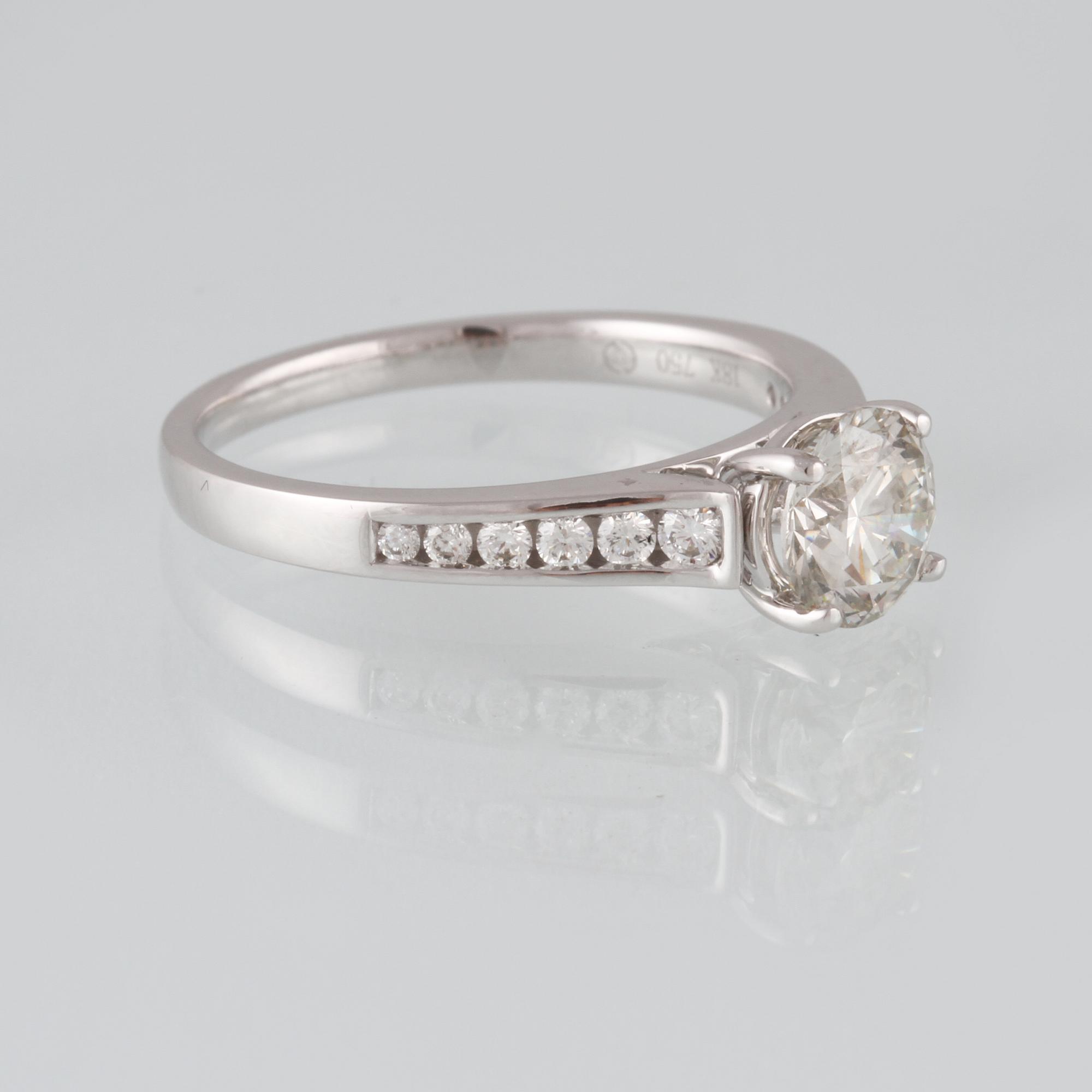 RING, 18K vitguld med briljantslipad diamant 1.01 ct samt 12 briljantslipade diamanter 0.20 ct. Vikt 3,6 gram.
