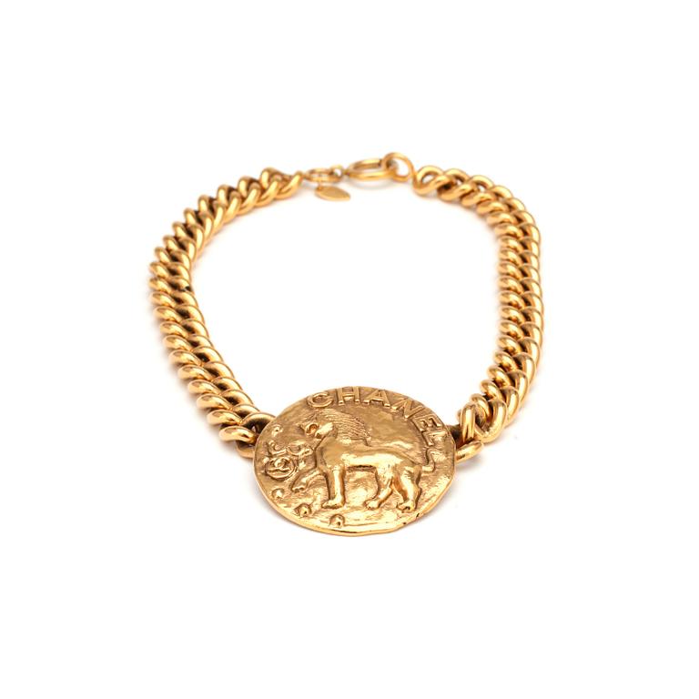 CHANEL, a gold colored chain necklace with medallion.