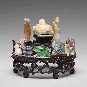 An arrangement of stone sculptures on a wooden stand, China 20th Century.