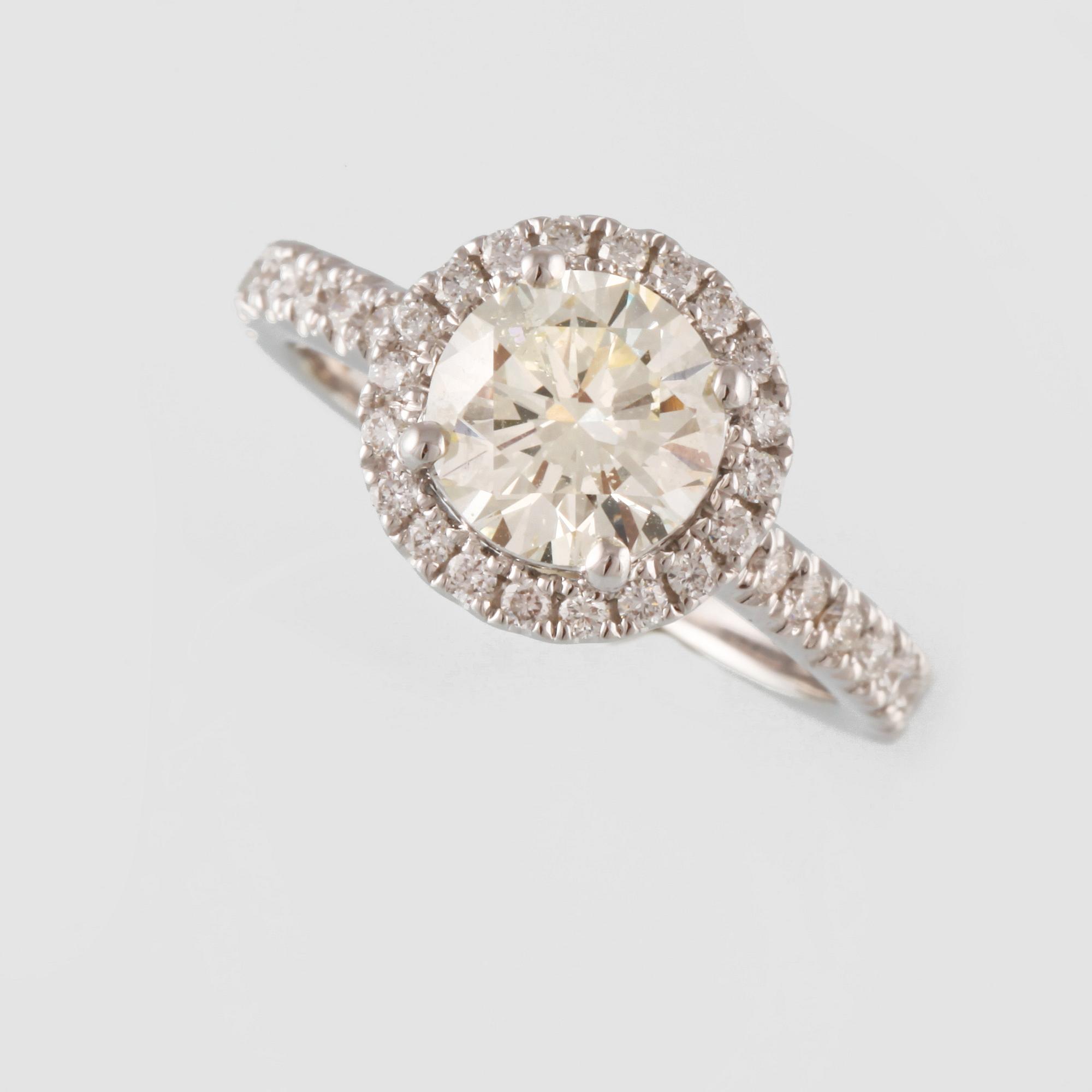 RING, 18K vitguld med en briljantslipad diamant 1.44 ct samt små briljantslipade diamanter 0.50 ct. Vikt 4,6 gram.