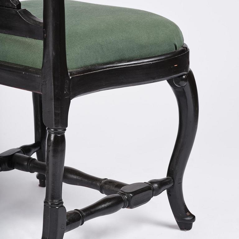 A set of eight black Swedish rococo chairs.