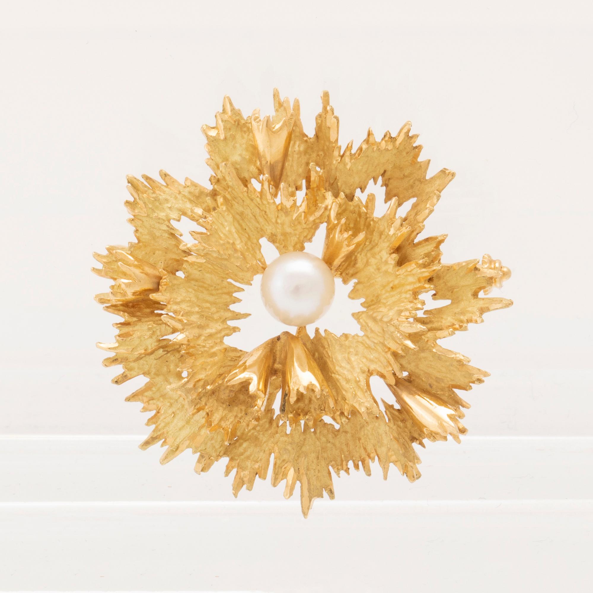 An 18K gold brooch set with a cultured pearl.