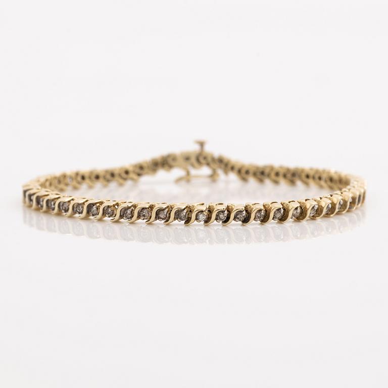 Tennis bracelet 14K gold with round brilliant-cut diamonds.