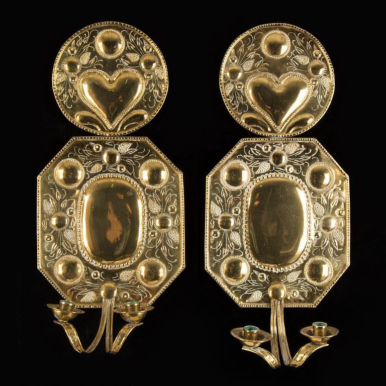A pair of first half of the 20th century brass two-light wall sconces.