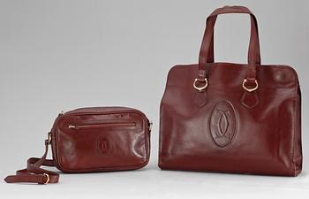 1454. A set of two 1970s bordeaux leather handbags by Cartier.