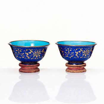 A pair of gilt decorated blue ground painted enamel bowls, Qianlong four character seal mark and period (1736-95).