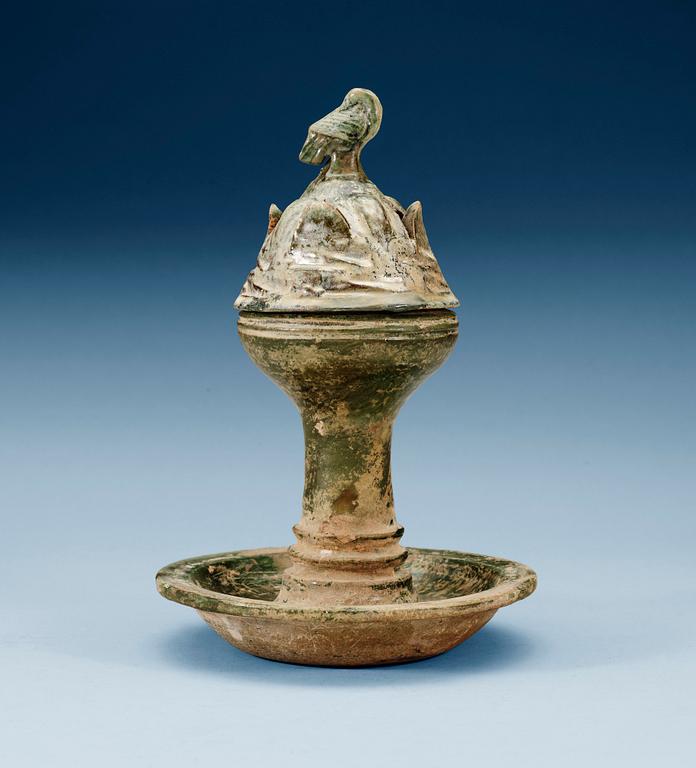 A green glazed pottery Hill Jar, cover with bird shaped finial, Han dynasty (206 BC-AD 220).