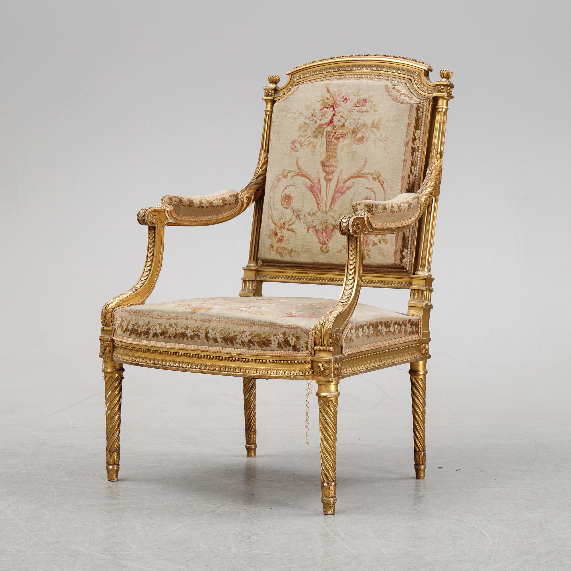A gilt Louis XVI style armchair from around the year 1900.