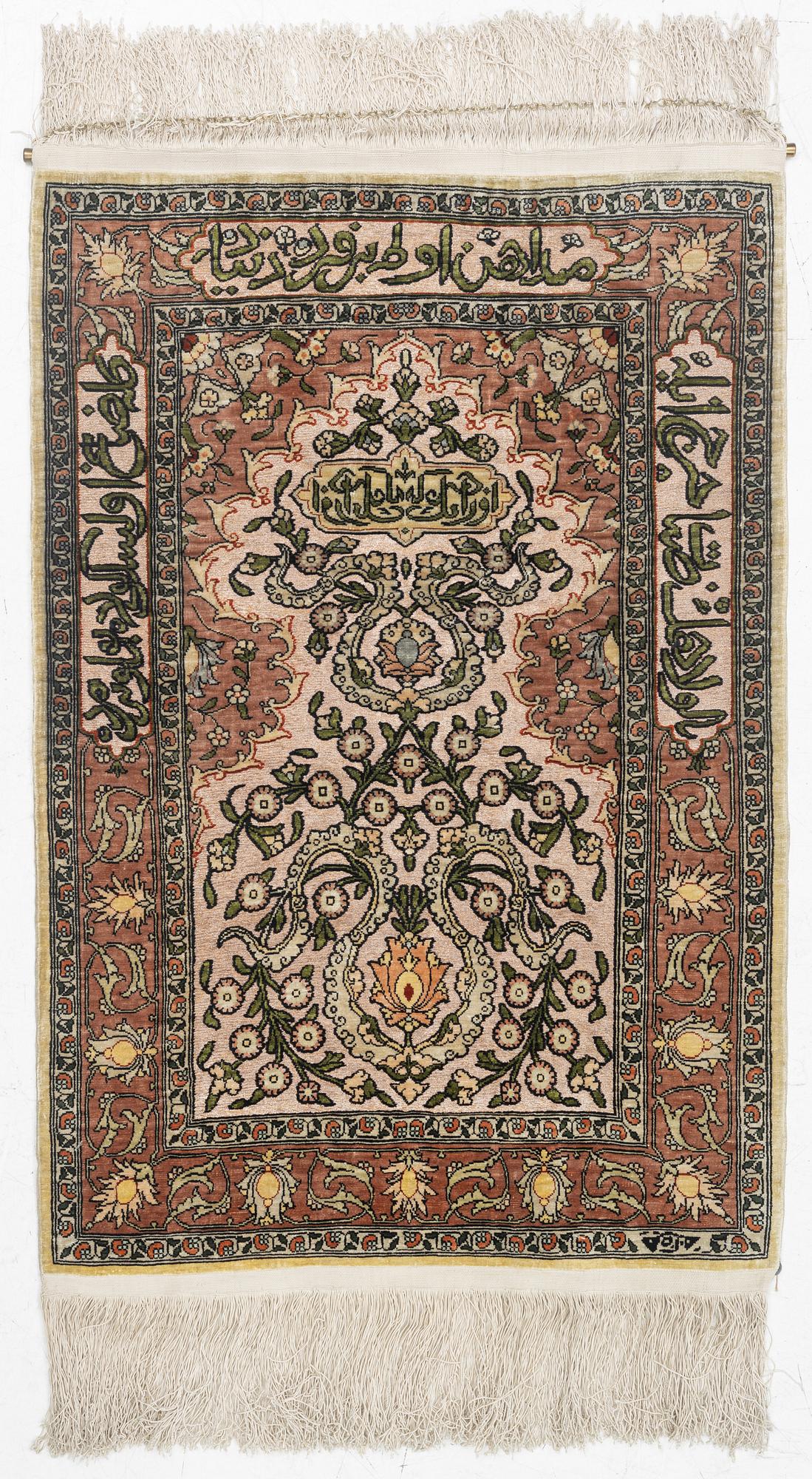 A silk Hereke rug, c. 77 x 53 cm.