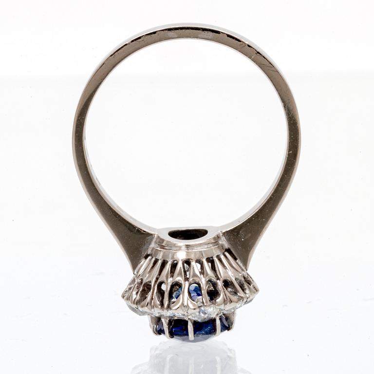 An 18K white gold ring with an oval old cut sapphire and round brilliant and old cut diamonds.