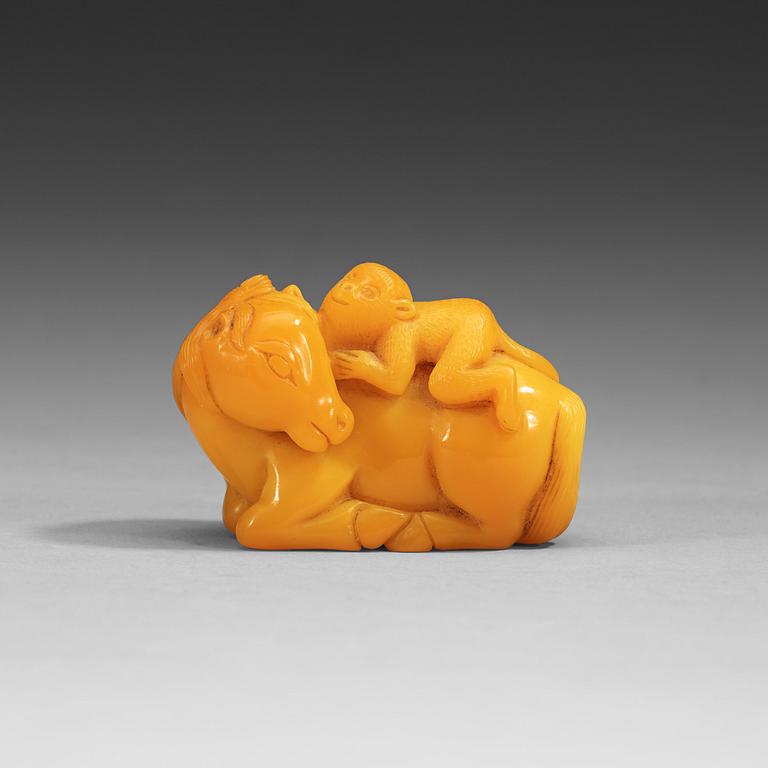 A glass figure of a reclining horse with a monkey, late Qing dynasty (1644-1912).